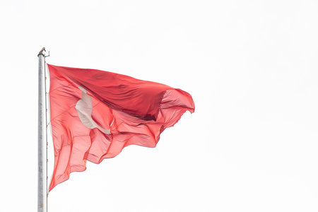 National flag of Turkey on a flagpole waving against a blue sky