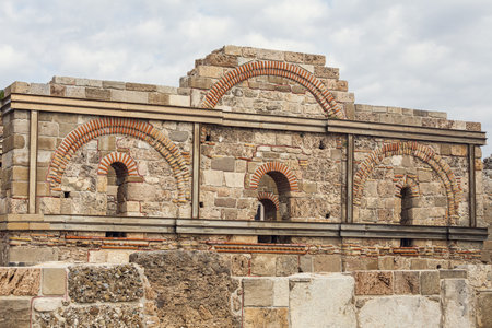 Sights of ancient Side, Turkey. Two-story building with arched windows. Fragments of stone walls.