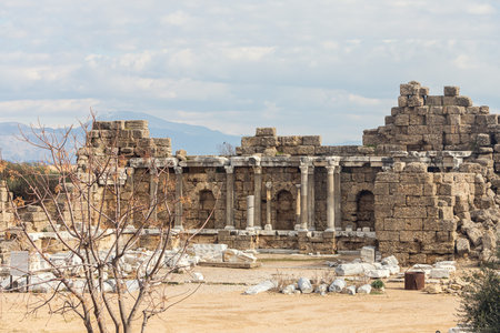 Sights of ancient Side, Turkey. Two-story building with arched windows and columns. Fragments of...