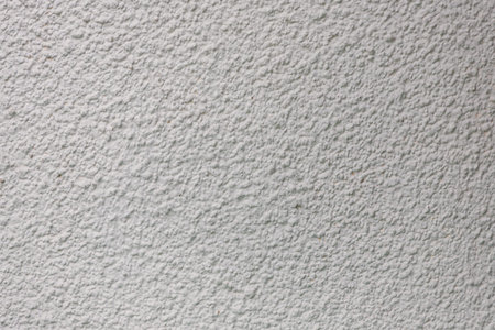 Background from a pattern of gray stone wall covered with decorative plaster.