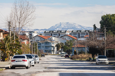 Side, Turkey -January 20, 2022: City street with different low rise houses, cars parking and mountain on backgroundのeditorial素材