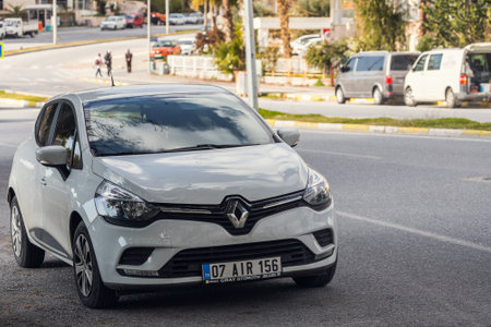 Side, Turkey -January 19, 2022: white Renault Clio is parked on the street on a warm summer day against the backdrop of a buildung, trees, shopsのeditorial素材