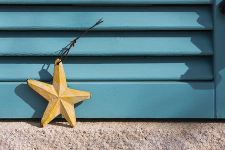 Souvenirs, yellow wooden starfish against a blue window for sale in a storeの写真素材