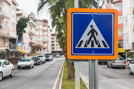 pedestrian crossing road sign on a city backgroundの写真素材