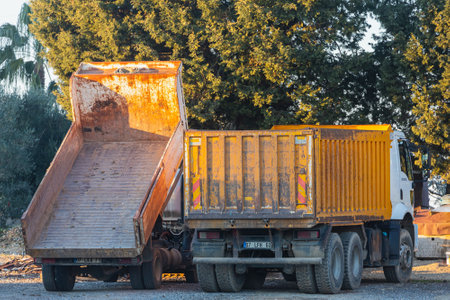 Side, Turkey -January 27, 2022: orange industrial truck and dump truck work on the background of constructionのeditorial素材