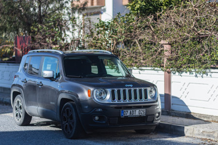 Side, Turkey -January 27, 2022: black Jeep Renegade is parking on the street on a summer day against the backdrop of a building, fence, parkのeditorial素材