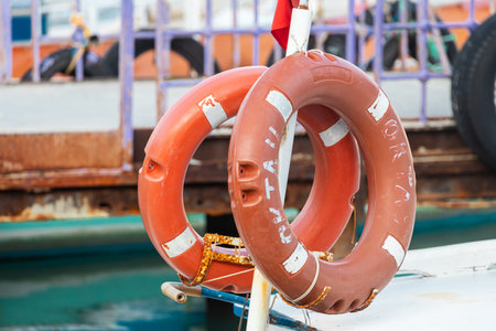close-up lifebuoy on a boat. Red lifebuoy on ship railing with sea surface