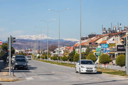 Side, Turkey â February 02 2022: city street with multi-storey houses of the same type, parked different cars , shops, mountainsの写真素材