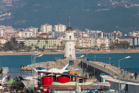 Alanya, Turkey â February 16 2022: A pier with a beautiful white lighthouse and many boats, yachts on the background of the blue seaのeditorial素材