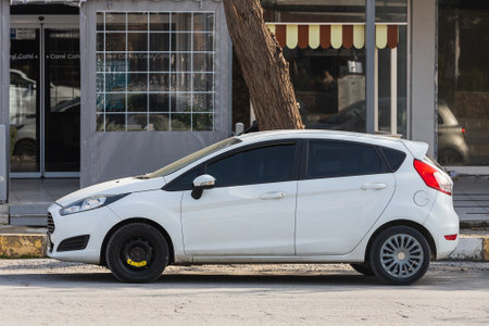 Side, Turkey -February 18, 2022: white Ford Fiesta is parked on the street on a warm day against the backdrop of a buildung, park, fence, shopsのeditorial素材