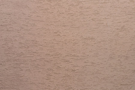 Background from a pattern of beige stone wall covered with decorative plaster.