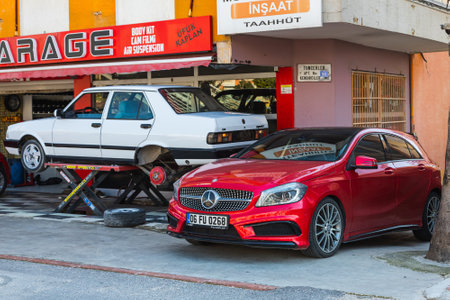 Antalya; Turkey â March 04 2022: yellow Tofas Dogan car on a lift at a tire shop and red Mercedes-Benz A-classのeditorial素材