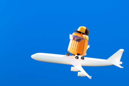 Yellow suitcase in a cap and sunglasses on a plane to fly on vacation. travel concept. 3d renderingの写真素材