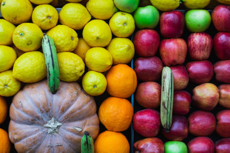 close-up of a shop window with selected fresh fruits: apples, oranges, coconuts, pineapples for a healthy lifestyleの写真素材