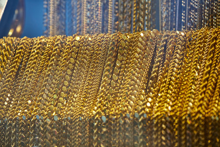 Close up of the jewelry gold necklaces ring, chains show in beauty retail store window display...
