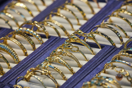 Close up of the jewelry gold necklaces ring, bracelets, show in beauty retail store window display showcase background.の写真素材