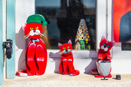 Multicolored wooden cat souvenirs stand in a row for sale in a storeの写真素材