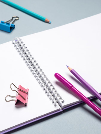 Creative flat design desktop mockup with empty notebook, stationery on blue background