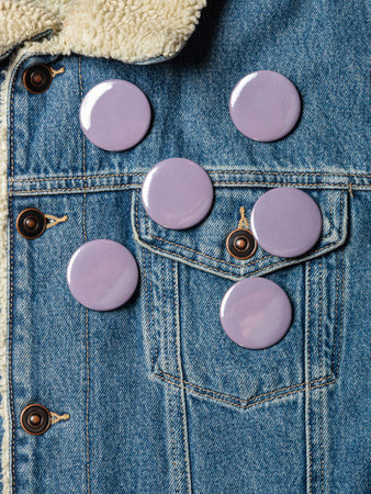 gray round badge button on denim jacket. Badge on a jacket close-up view. texture background