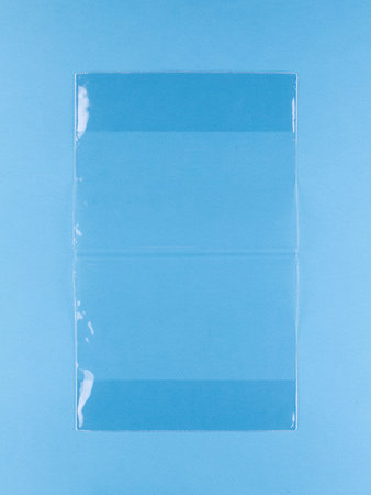 Close-up of transparent covers for a textbook and notebook on a blue background