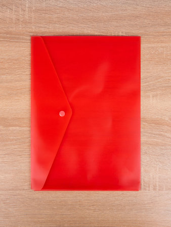 Red plastic folder , envelope for documents isolated on blue background