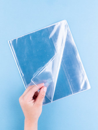 Close-up of transparent covers for a textbook and notebook on a blue backgroundの写真素材