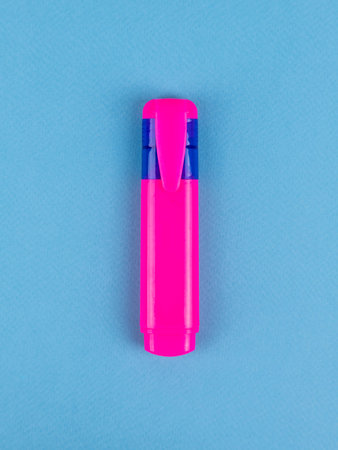 Pink marker close up isolated on blue e background.
