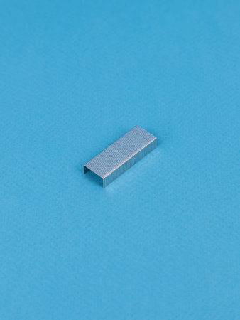 Close up stack of metal staples for stapler on a wooden table