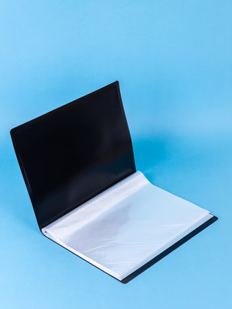 Black plastic office folder on blue background. Office Folder Templateの写真素材