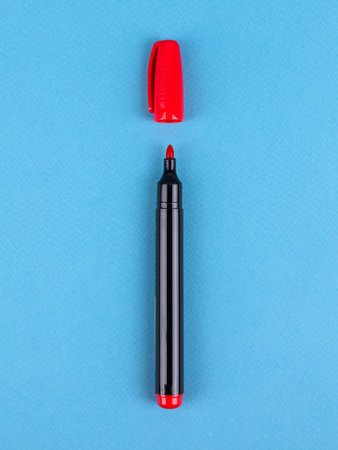 Red felt-tip pen markers highlighters close-up, isolated on blue backgroundの写真素材