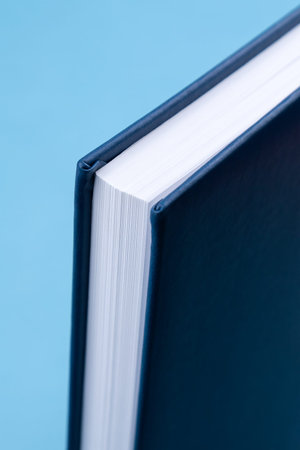 Studio shot of a blue corner of a hardcover notebook, close-up