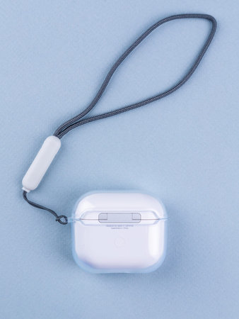 close up of wireless headphone case on blue background