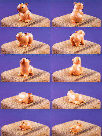 Close-up of a company of small, cute figurines shaped like brown capybaras, displayed on a wooden podiumの写真素材
