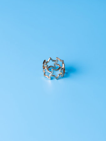 Close-up of a golden ring with stars against a blue background