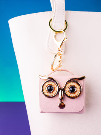 A close-up of a small pink leather mini bag featuring an owl design with bright, expressive eyes on white bagの写真素材