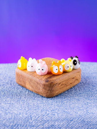 A close-up of a set of colorful, adorable animal interior figurines in kawaii style, placed on a wooden stageの写真素材