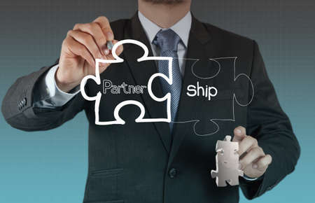 businessman hand shows light and puzzle partnershipの写真素材