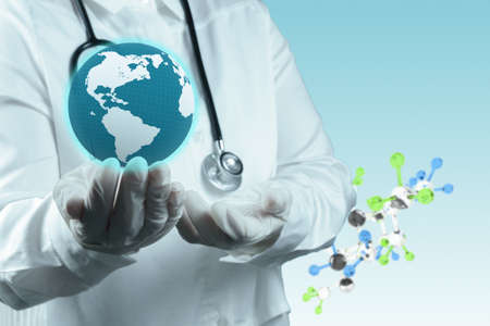 Stethoscope in hand with capsule pill and molecule as medical conceptの写真素材