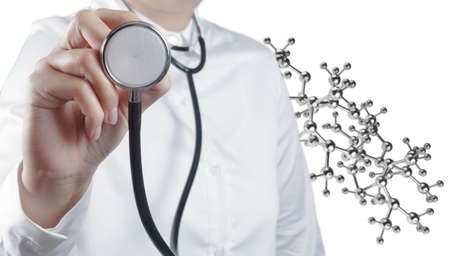 Stethoscope in hand with capsule pill and molecule as medical conceptの写真素材