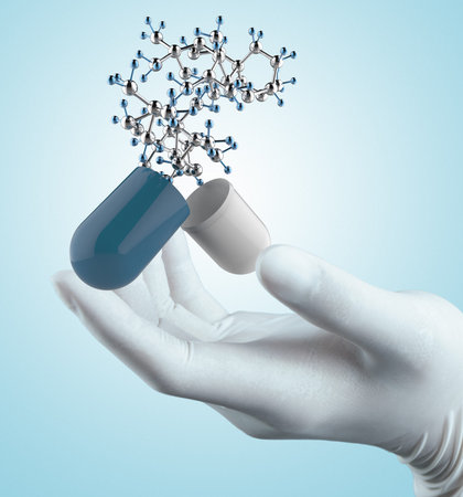 Stethoscope in hand with capsule pill and molecule as medical conceptの写真素材