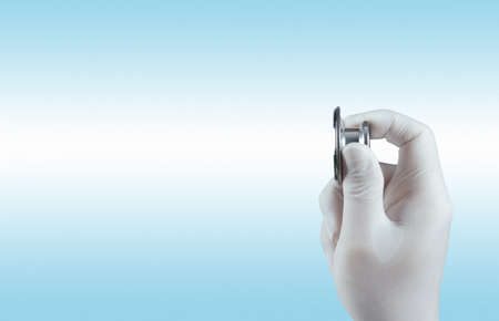 Stethoscope in hand with patient word as medical conceptの写真素材