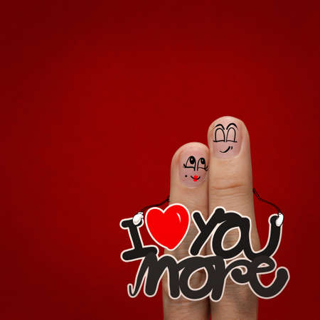the happy finger couple in love with painted smiley and hold word love you moreの写真素材