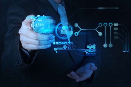 businessman hand pushing  new technology button on modern computer as conceptの写真素材