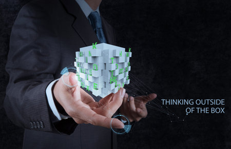 businessman hand shows word thinking outside the box as concept