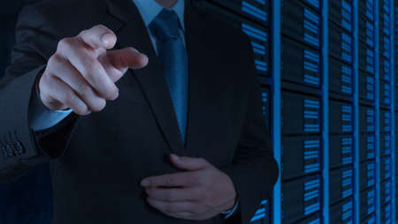 businessman hand pressing a touchscreen button on server backgroundの写真素材