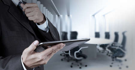 Businessman hand working with a digital tablet on meeting room backgroundの写真素材