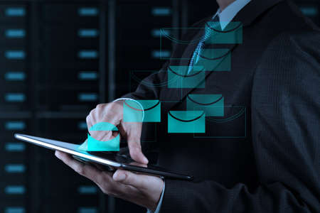 businessman hand using tablet computer and server room backgroundの写真素材