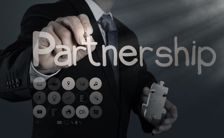 businessman hand shows light and puzzle partnershipの写真素材