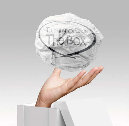 hand shows crumpled paper and think outside the box as conceptの写真素材