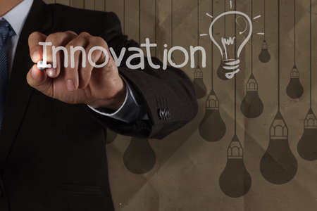 businessman hand draws innovation  light bulb with recycle envelope background as creative conceptの写真素材